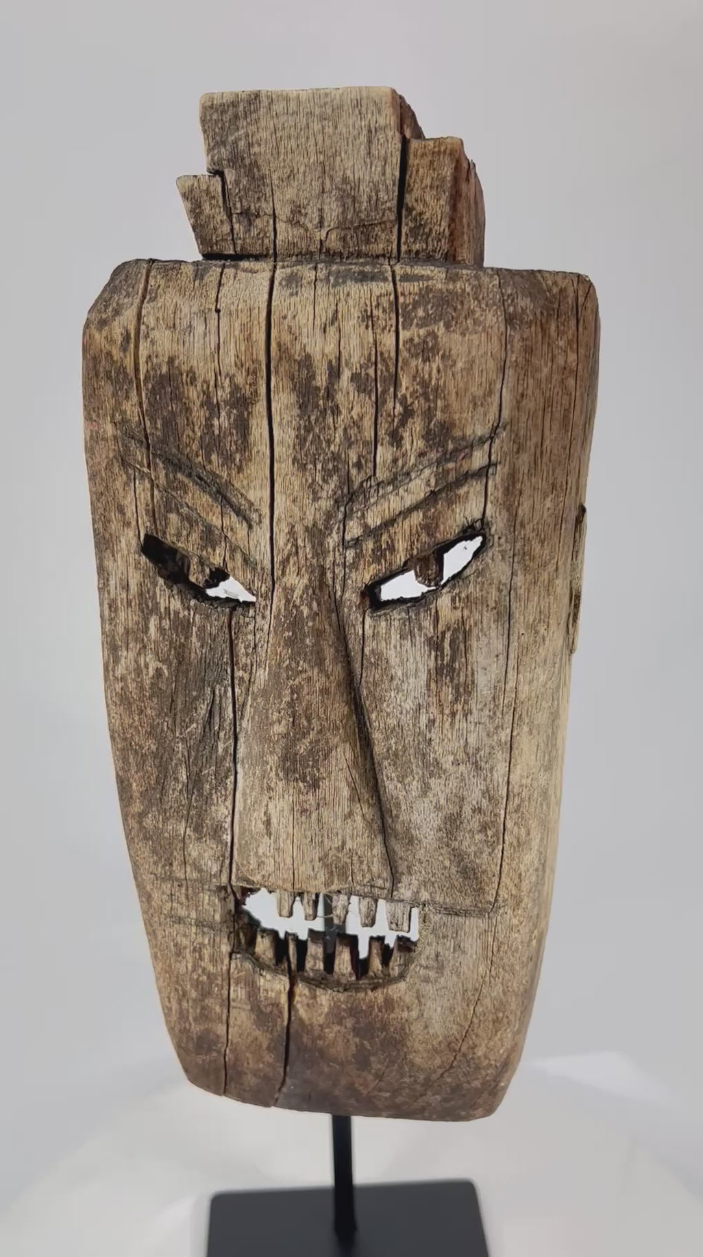 360° rotation video of early 20th-century ritual hardwood mask from Northern Thailand or Laos showing angular carving, rich patina, and traces of ceremonial soot.