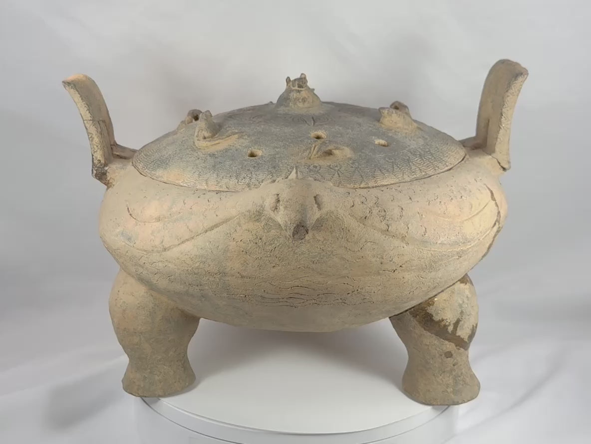360-degree video of a large ancient Chinese terracotta zoomorphic ritual vessel from the Eastern Zhou to Han Dynasty, showcasing its pierced domed lid, tripod feet, upright handles, incised decoration, archaeological patina, and sculptural ceremonial form.