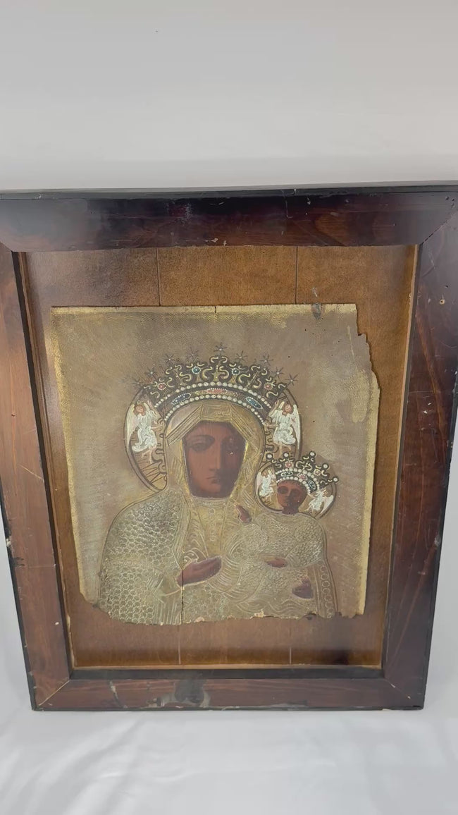Close-up video examination of a 19th-century Eastern European icon of Our Lady of Częstochowa, highlighting the embossed metal riza, jeweled crowns, angelic details, painted faces, and intricate devotional ornamentation.