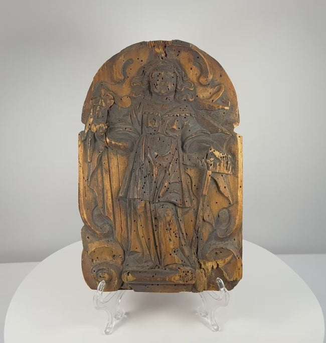 Rotating view of a heavily weathered 19th-century Continental European carved wooden devotional relief depicting an unidentified Christian saint beneath an arched frame