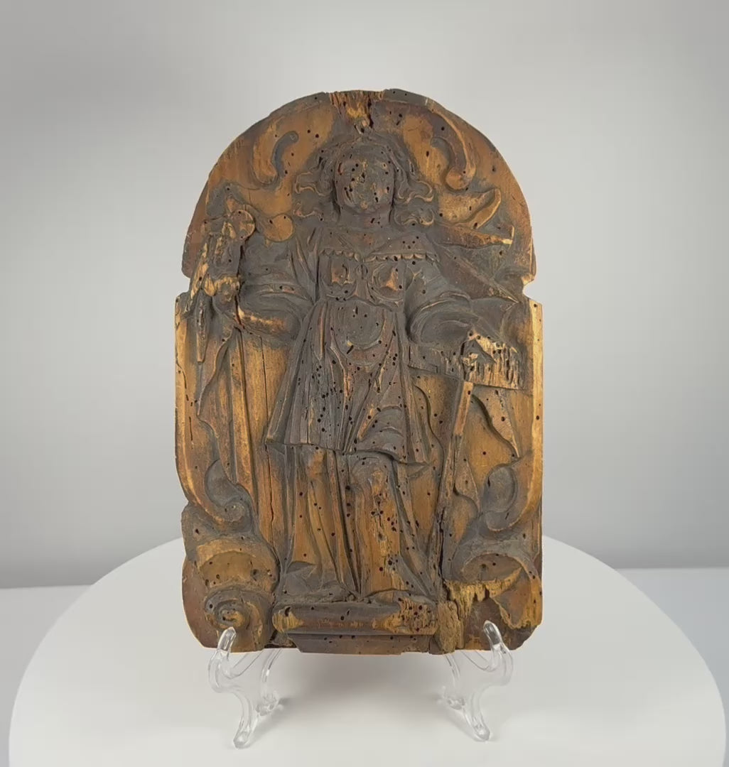 Rotating view of a heavily weathered 19th-century Continental European carved wooden devotional relief depicting an unidentified Christian saint beneath an arched frame