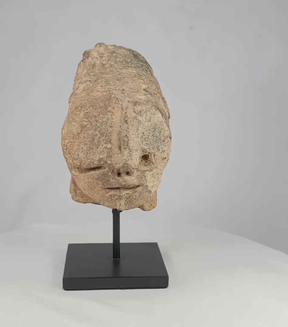 Bura Culture terracotta head fragment on black display stand, shown rotating to reveal multiple angles and surface details.