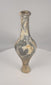 Rotating view of an ancient Iranian Plateau grayware spindle-form bottle with a rounded globular body, tall narrow neck, thickened everted rim, twin horizontal shoulder ridges, narrow lower stem, raised circular pedestal foot, dark grey to black burnished surface, wheel-forming marks, pale mineral deposits, burial accretions, rim wear, and archaeological patina