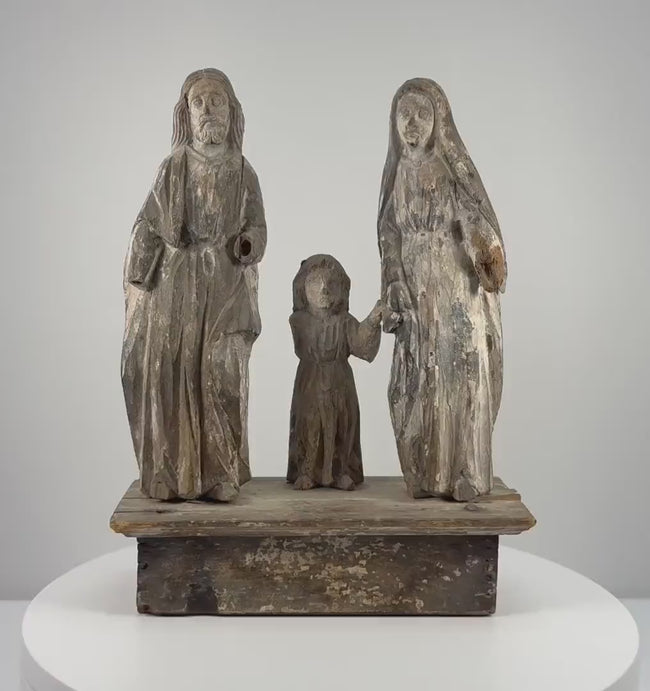 Antique Spanish Colonial Holy Family wooden santo from the Philippines, dating to the 18th–19th century, featuring hand-carved figures of Jesus, Mary, and Joseph, softened facial details, remnants of original painted decoration, natural wood patina, age-related surface wear, and an integral carved wooden platform.