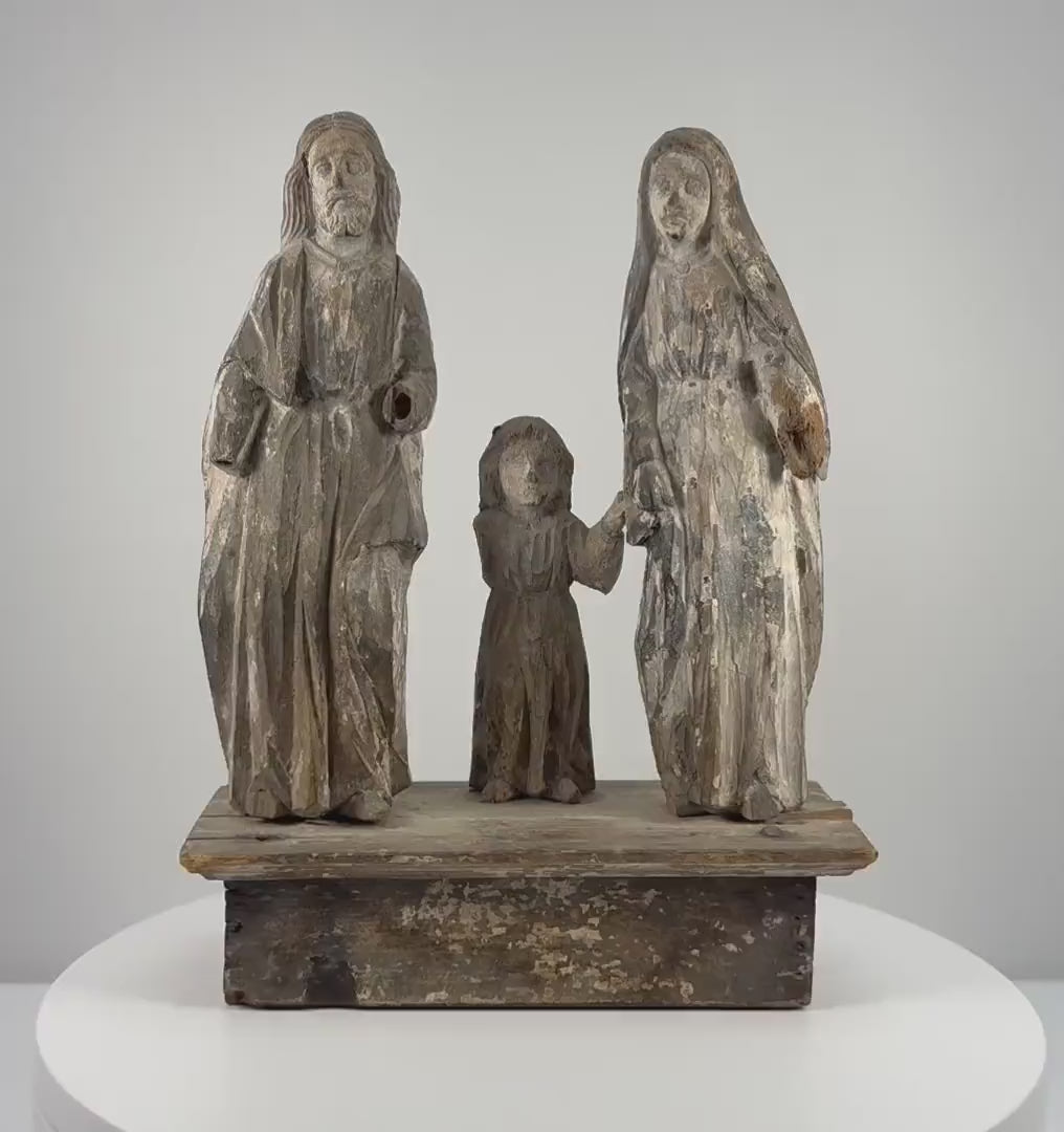 Antique Spanish Colonial Holy Family wooden santo from the Philippines, dating to the 18th–19th century, featuring hand-carved figures of Jesus, Mary, and Joseph, softened facial details, remnants of original painted decoration, natural wood patina, age-related surface wear, and an integral carved wooden platform.