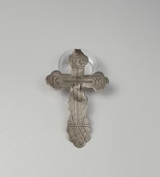 Video showcasing a late 19th-century Russian Orthodox silver pendant cross, highlighting its engraved Crucifixion imagery, scalloped terminals, traditional Orthodox inscriptions, aged silver patina, and 84 zolotnik hallmark on the reverse.