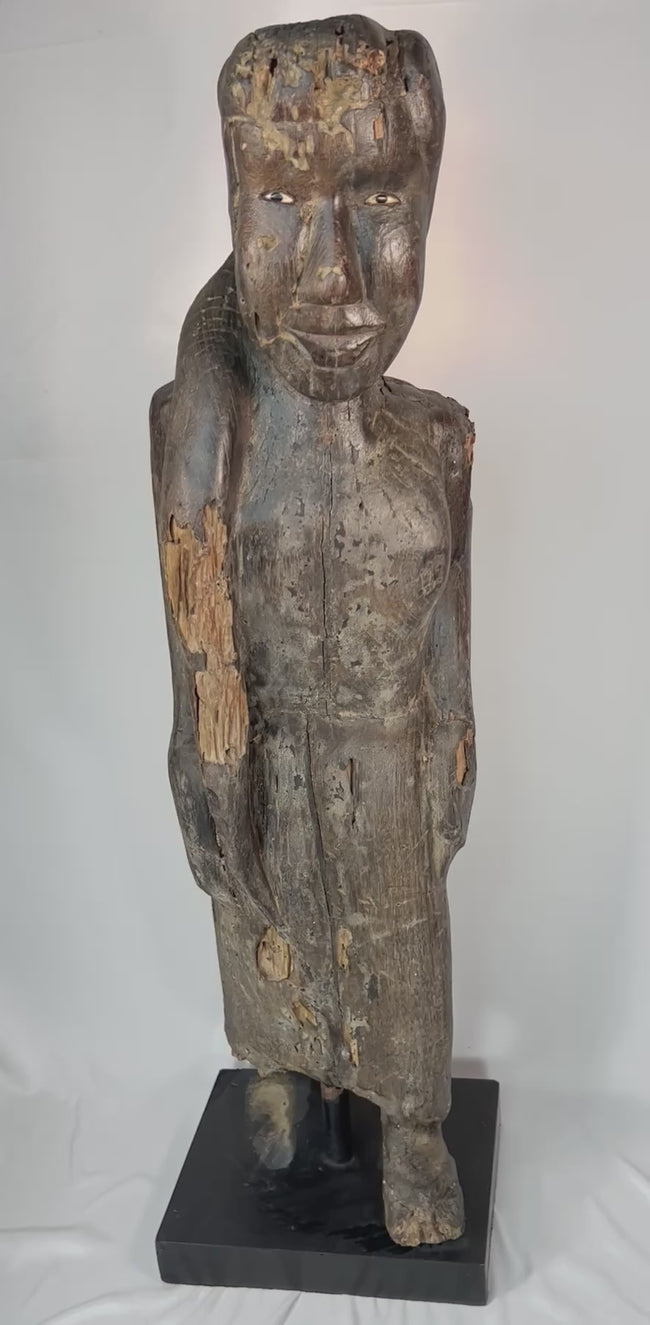 Close-up video highlighting the carved facial features, inset eyes, and aged surface of a Dayak ancestral sculpture