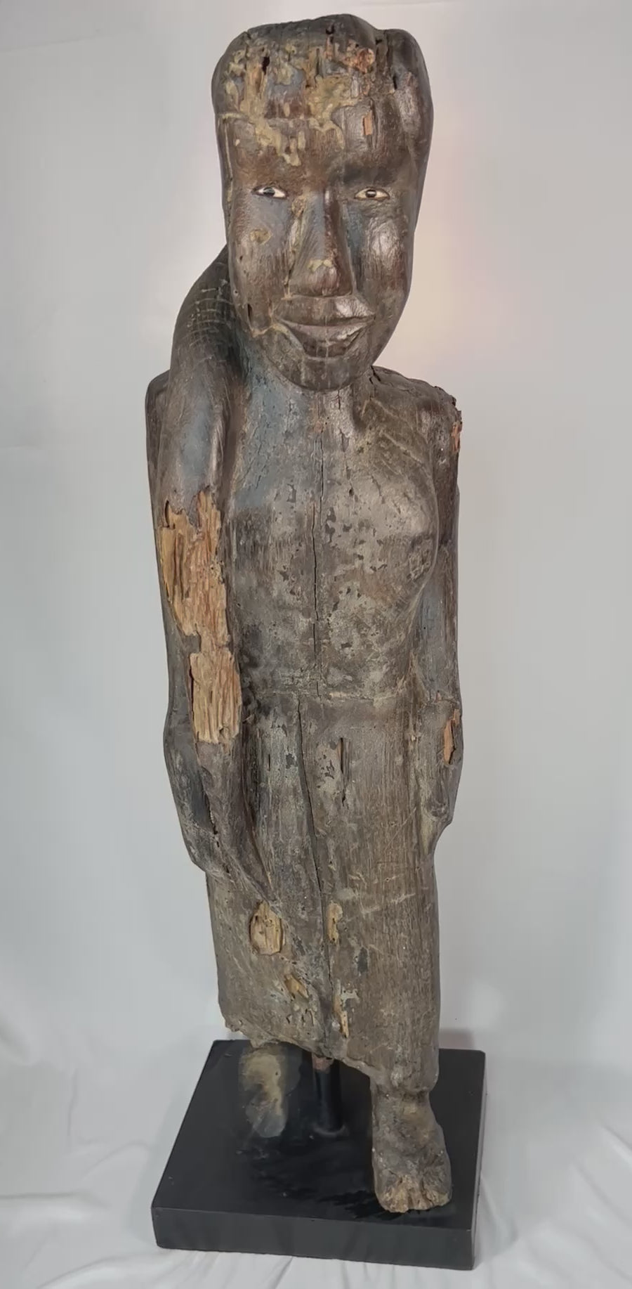 Close-up video highlighting the carved facial features, inset eyes, and aged surface of a Dayak ancestral sculpture