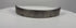 Antique 17th-century European forged steel armor band formerly held in the Higgins Armory Museum collection, featuring a thick curved structure, evenly spaced rivet holes, traditional hand-forged metalwork, natural aged patina, surface pitting, and historic wear characteristic of early modern European defensive armor.