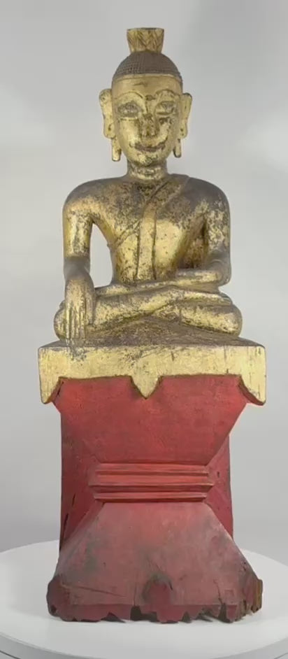 Rotating view of an antique Burmese Shan (Tai Yai) seated Buddha sculpture in Bhumisparsha Mudra, highlighting its carved hardwood construction, surviving gilding, lacquered red plinth, devotional wear, and prominent ushnisha finial.