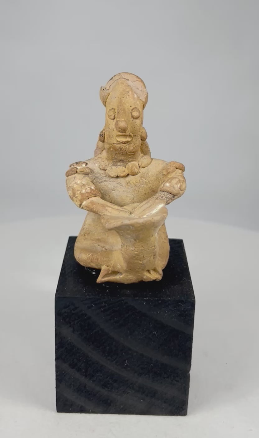 360-degree video of an ancient Pre-Columbian West Mexican terracotta seated drummer effigy, showing full sculptural detail, adornments, drum placement, and original surface patina