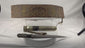 Rotating view of a late 19th-century Tibetan embroidered belt and dagger ensemble with a single-edged steel blade, faceted horn handle, silvered guard, leather-covered wooden scabbard, embossed metal mounts, suspension cord, and richly decorated textile belt
