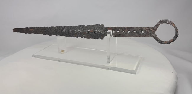 14th-century European dagger with quillon guard and ring pommel — forged steel blade with iron hilt, showcased on acrylic display stand. Medieval weaponry artifact video.