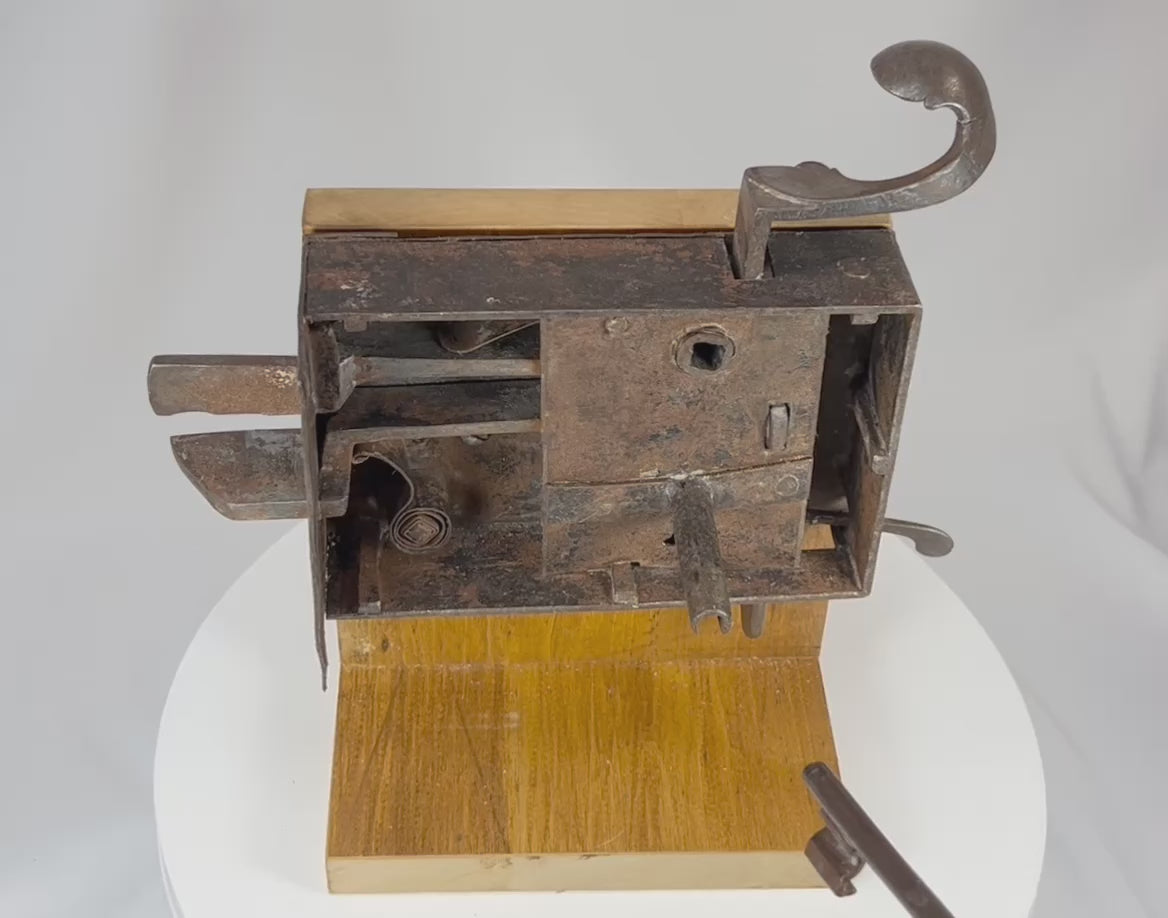 Demonstration of antique iron lock mechanism as key is turned, activating internal levers and sliding bolts