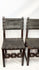 Close-up video zooming in on a pair of 17th-century Spanish Baroque walnut chairs with studded leather upholstery.