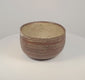 Rotating red-brown ceramic bowl showing cream X-shaped and diamond patterns, horizontal decorative bands and a pale buff interior.
