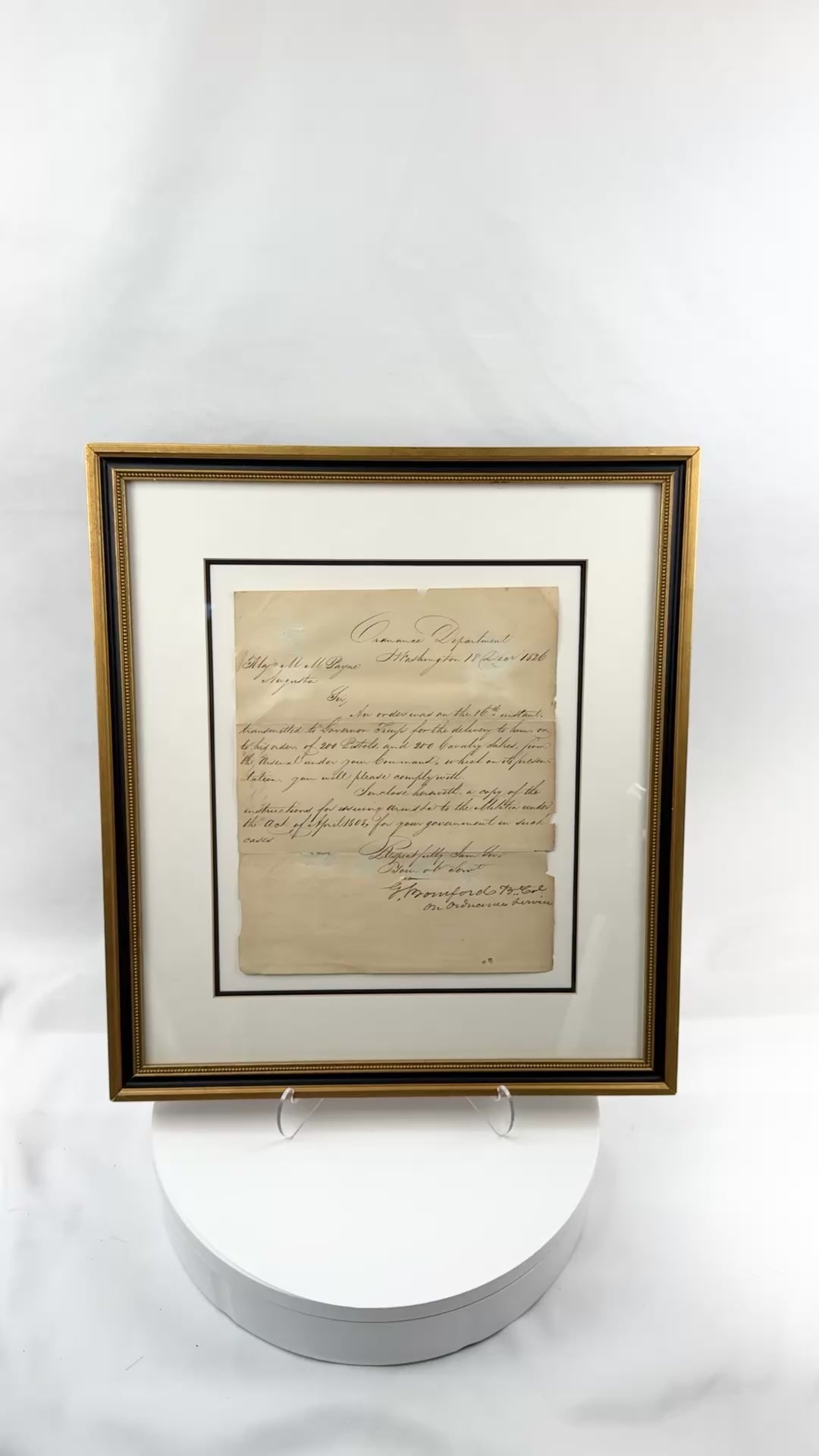 Video view of an original 1826 United States Ordnance Department letter signed by Colonel George Bomford, addressed to Major Mathew Mountjoy Payne, ordering the delivery of 200 pistols and 200 cavalry sabres, shown within a black and gilt conservation frame with archival matting, UV-filtering glass, period handwriting, fold lines, toning, edge wear, and reverse framing labels