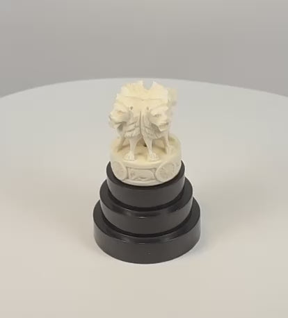 Rotating video of an Indian Lion Capital of Ashoka miniature showing four carved lions, wheel motifs, and the tiered ebonized wood base.