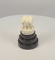 Rotating video of an Indian Lion Capital of Ashoka miniature showing four carved lions, wheel motifs, and the tiered ebonized wood base.