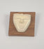 Rotating view of a mid-20th century hand-carved animal bone spirit face sculpture mounted on a polished hardwood plaque, highlighting its minimalist facial features, natural patina, and tribal-inspired modernist design.