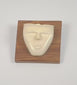 Rotating view of a mid-20th century hand-carved animal bone spirit face sculpture mounted on a polished hardwood plaque, highlighting its minimalist facial features, natural patina, and tribal-inspired modernist design.