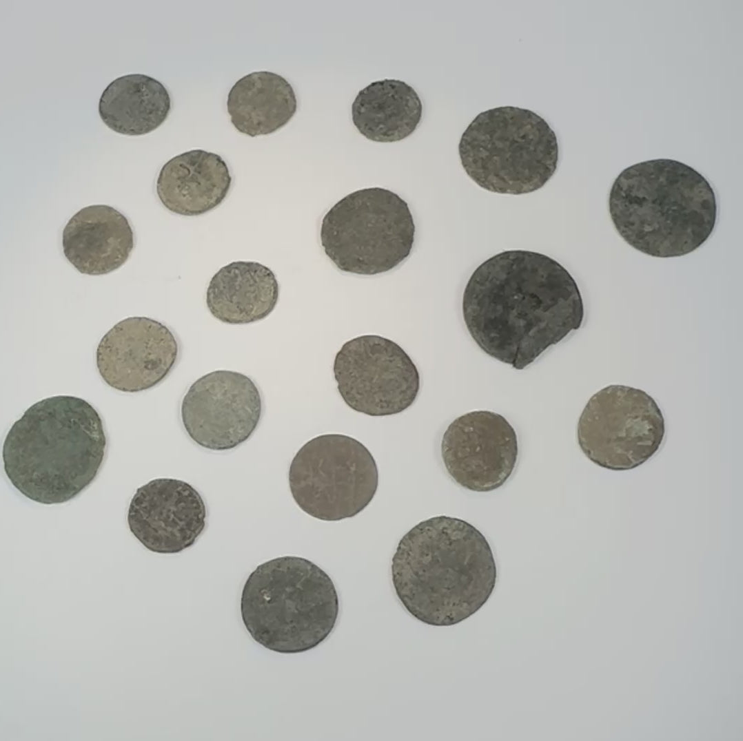 360-degree overview of a collection of twenty ancient Roman, Late Antique, and possible early Byzantine bronze coins showing varied flan sizes, patination, corrosion, and surviving design details.