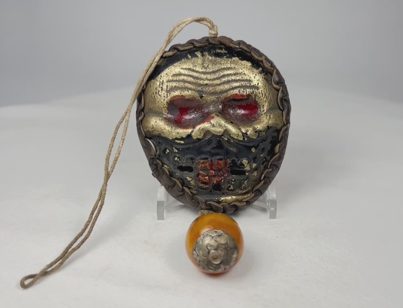 360-degree view of Himalayan protective skull mask amulet with leather backing and ritual drop ornament