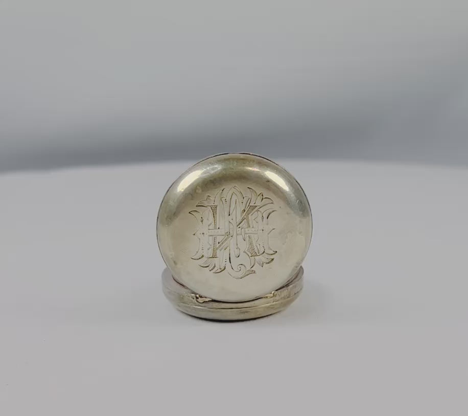 360-degree view of an antique Victorian sterling silver sovereign holder from the 1880s, featuring engraved monogram and spring-loaded coin case design.