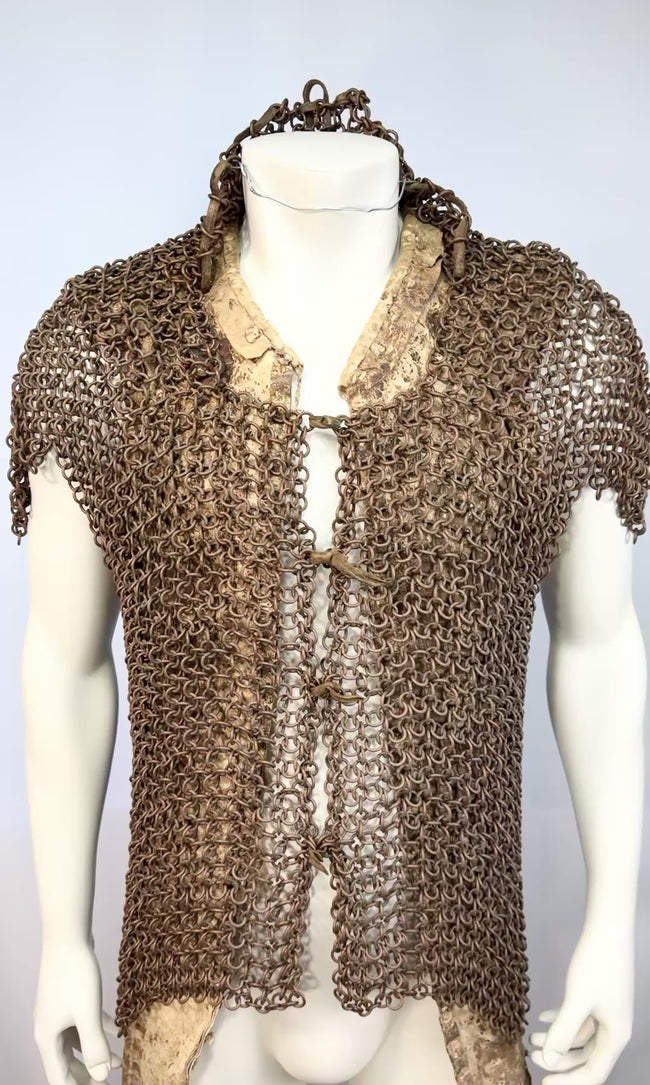 Zoomed in video of antique Moro mail armour showing the bronze rings, peaked shoulders, hide undercoat, collar, and front ties