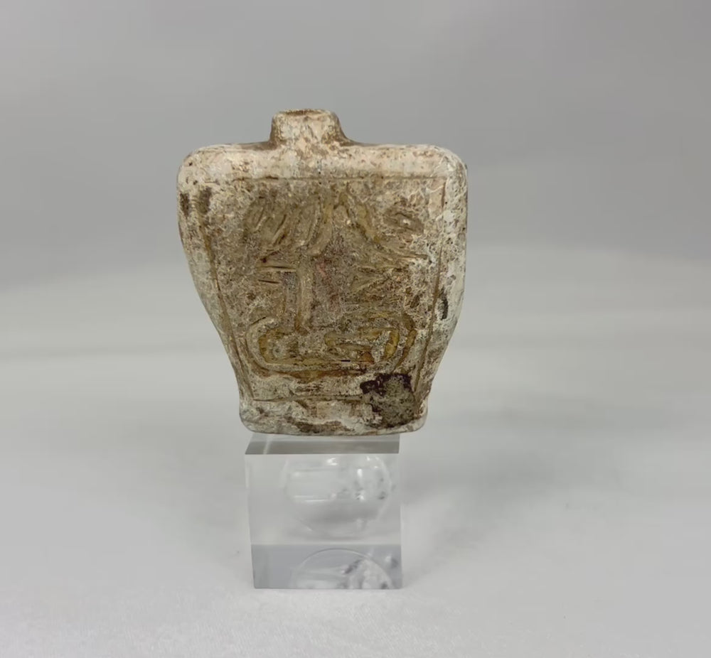 Rotating video of an ancient carved stone amulet flask with double-sided motifs.