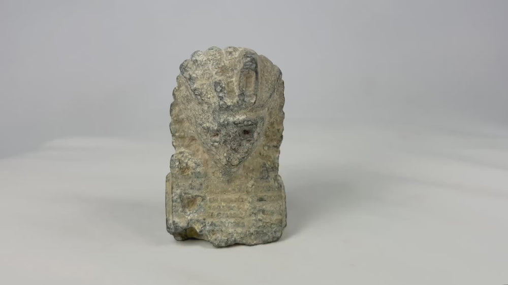 Video of arved limestone pharaoh head with nemes headdress and uraeus cobra motif, European Grand Tour collectible circa 1800–1920 on neutral background.