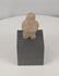 Rotating view of a Pre-Columbian carved stone standing figure with folded arms, deeply recessed eyes, compact proportions, weathered surfaces, mineral deposits, and a custom display stand