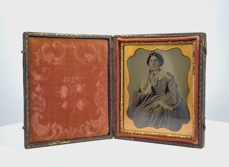 360-degree rotating view of an original mid-19th-century American cased portrait photograph, circa 1850–1865 CE, depicting an elegantly dressed Victorian woman. Features an ornate embossed case with gilt accents, decorative red velvet lining, and scalloped gilt-metal photographic mat. Formerly part of the Joseph W. Haley estate in Massachusetts and associated with the historic Sears family photographic collection.