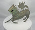 360-degree view of an antique Chinese bronze qilin sculpture with a horned head, open mouth, dorsal spines, arched tail, and naturally aged green patina.