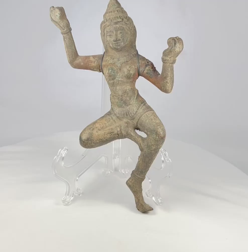 Bronze South Asian sculpture of a dancing deity, likely a Devata or Apsara, with ornate headpiece, flowing attire, and natural green patina, circa 12th–18th century CE.