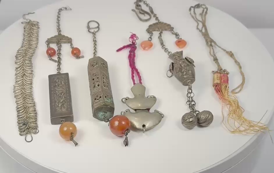 Video presenting six antique Chinese chatelaine, amulet and garment ornaments with silver-alloy metalwork, beads, bells and textile tassels