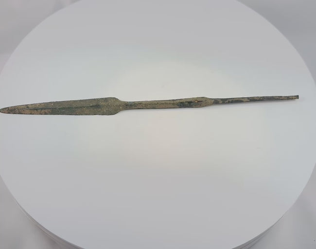 Video showing an Early Bronze Age bronze spearhead from Cyprus dating to circa 2500–1900 BCE, with a leaf-shaped blade, prominent raised midrib, reinforced central section, straight tang, and naturally aged burial patina.