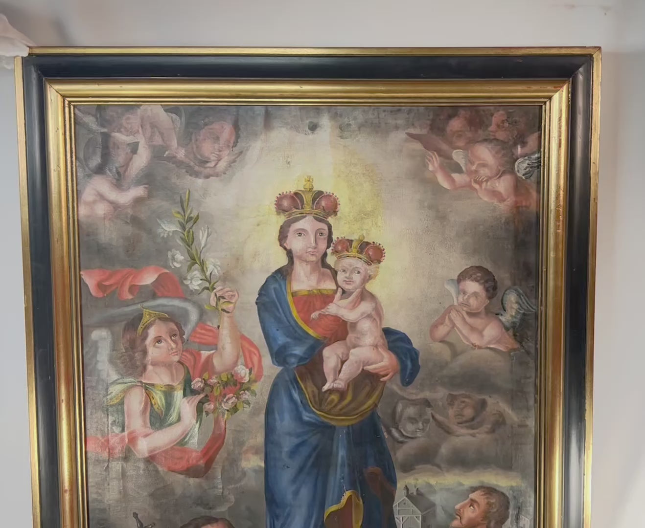 Large Andean Colonial oil painting of the crowned Madonna and Child with golden nimbus, surrounded by cherubic putti, kneeling pilgrim saint, and uniformed donor, Spanish-colonial architecture in background, bold Cuzco School palette, laid to wooden panel, late 18th–early 19th century, Peru.
