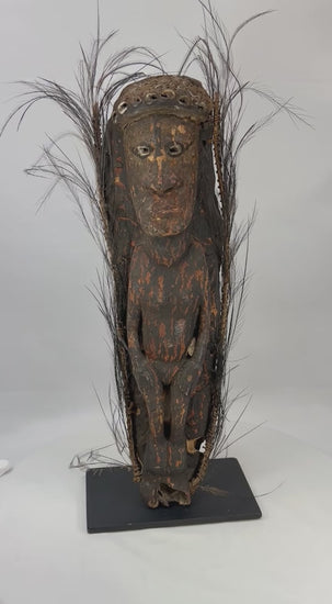 360-degree view of a Sepik River Papua New Guinea ancestor figure showing carved wooden form, shell eye inlay, feather adornments, ritual pigments, and aged ceremonial patina