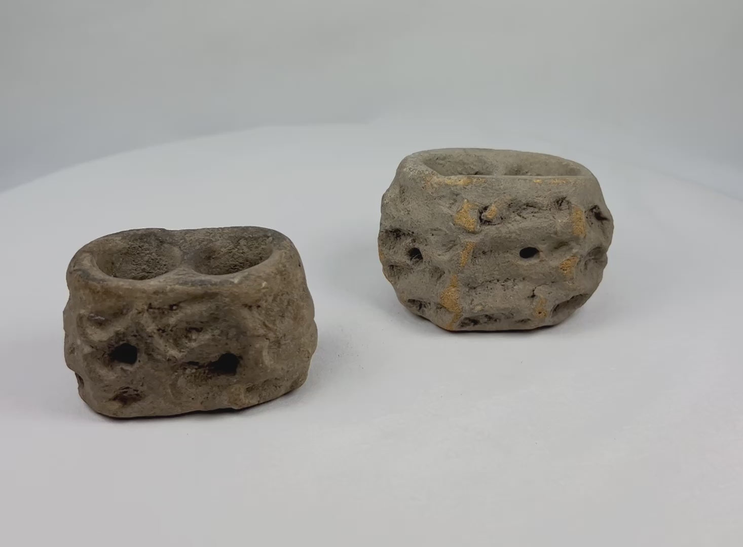 Ancient Pre-Columbian ceramic candelero vessel from Teotihuacan, Central Mexico, hand-modeled in sand-based clay with two circular openings, likely used as a brazier for incense or offerings, photographed on a white background.