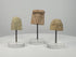 360° rotating video showcasing a set of three ancient Greek terracotta female protomai bust plaques, dating to the 6th–4th century BCE. Each fragment features distinct facial details, hairstyles, and headdresses, with natural patina and age-related wear. Individually mounted on clear acrylic display stands.