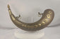 Rotating view of an antique Moroccan crescent-shaped brass powder horn with hand-engraved floral vinework, arabesque borders, ten embossed bosses, an original turned cap, decorative chain, suspension rings, and aged patina