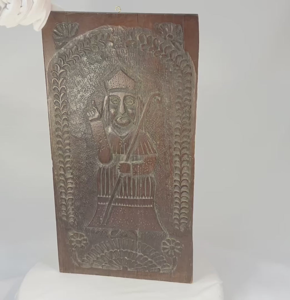 Video showcasing an antique European folk-carved devotional panel depicting a bishop saint in relief, late 18th–early 19th century