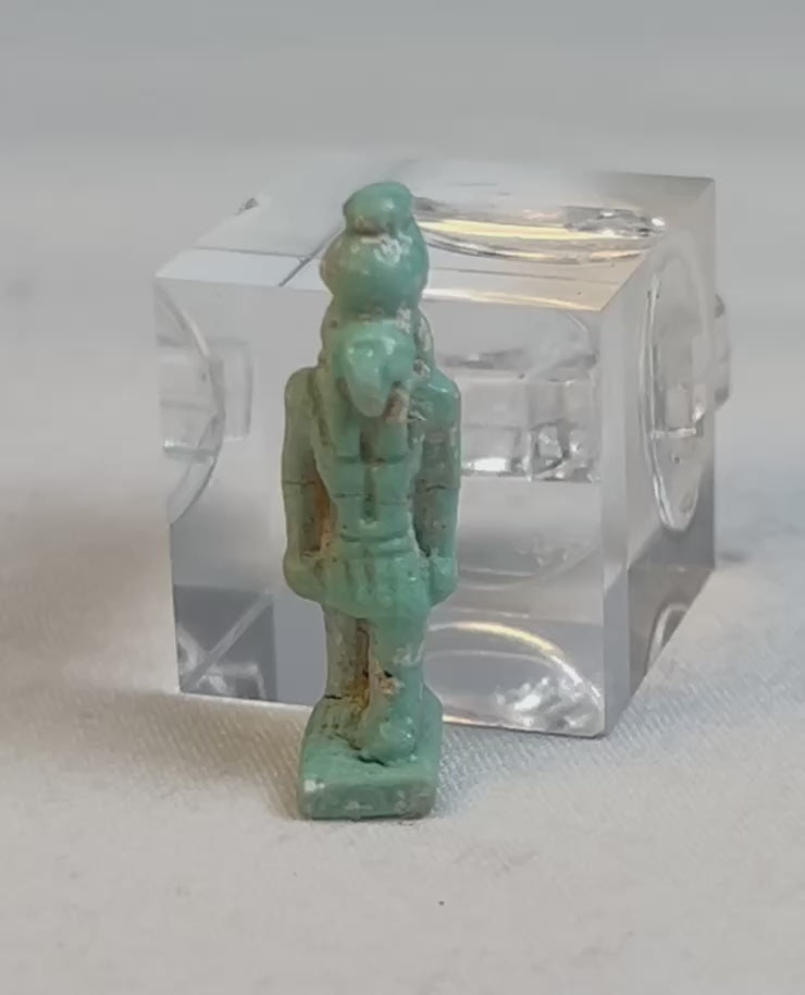Rotating video of an ancient Egyptian blue-green faience falcon-headed Horus amulet.