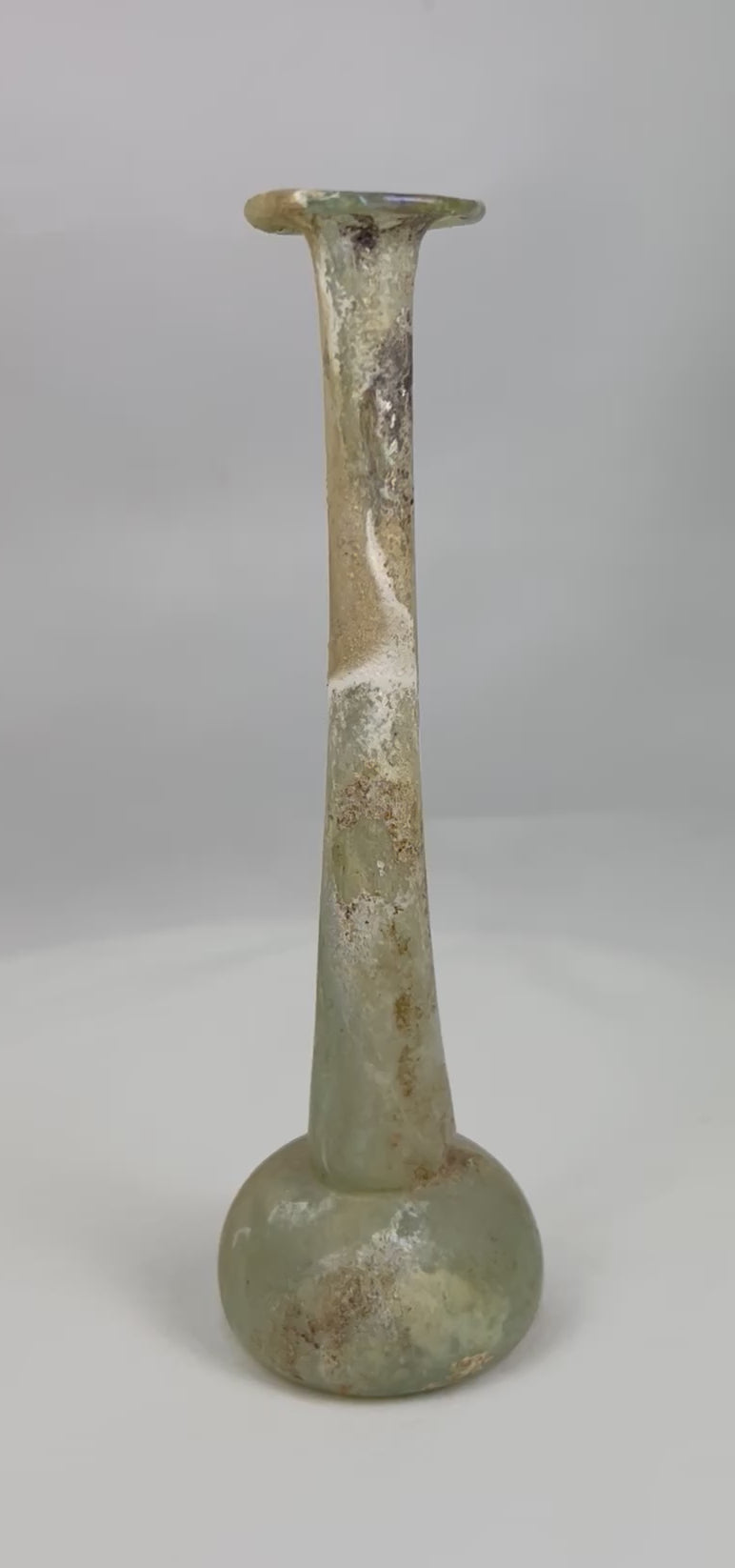 360° view of an ancient Roman glass unguentarium showing slender neck, rounded base, and beautiful archaeological patina