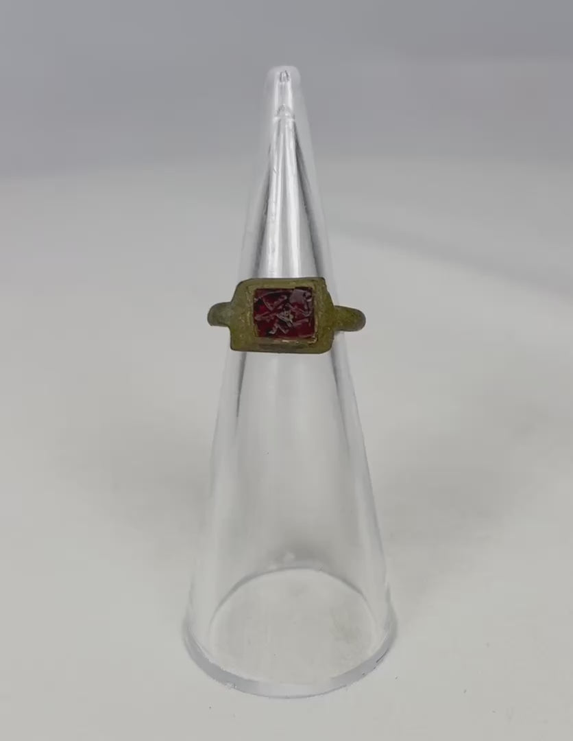 Rotating video of an ancient Roman bronze ring with a red glass intaglio centerpiece.