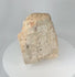 Rotating view of a medieval European carved stone ecclesiastical fragment depicting Christ on the Cross within an architectural niche, showing weathered relief carving, aged surface texture, and fragmentary architectural details.
