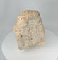 Rotating view of a medieval European carved stone ecclesiastical fragment depicting Christ on the Cross within an architectural niche, showing weathered relief carving, aged surface texture, and fragmentary architectural details.