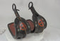 Pair of antique Japanese lacquered samurai stirrups from the Edo–Meiji period, featuring black lacquer finish and red cross-in-circle mon crest, displayed on a white background – Relic & Rarity.