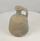 Rotating view of an ancient Iron Age Eastern Mediterranean or Levantine grey-fired earthenware jug with a rounded ovoid body, narrow cylindrical neck, thick flared rim, broad loop handle, mineral inclusions, firing pits, and an undecorated utilitarian surface